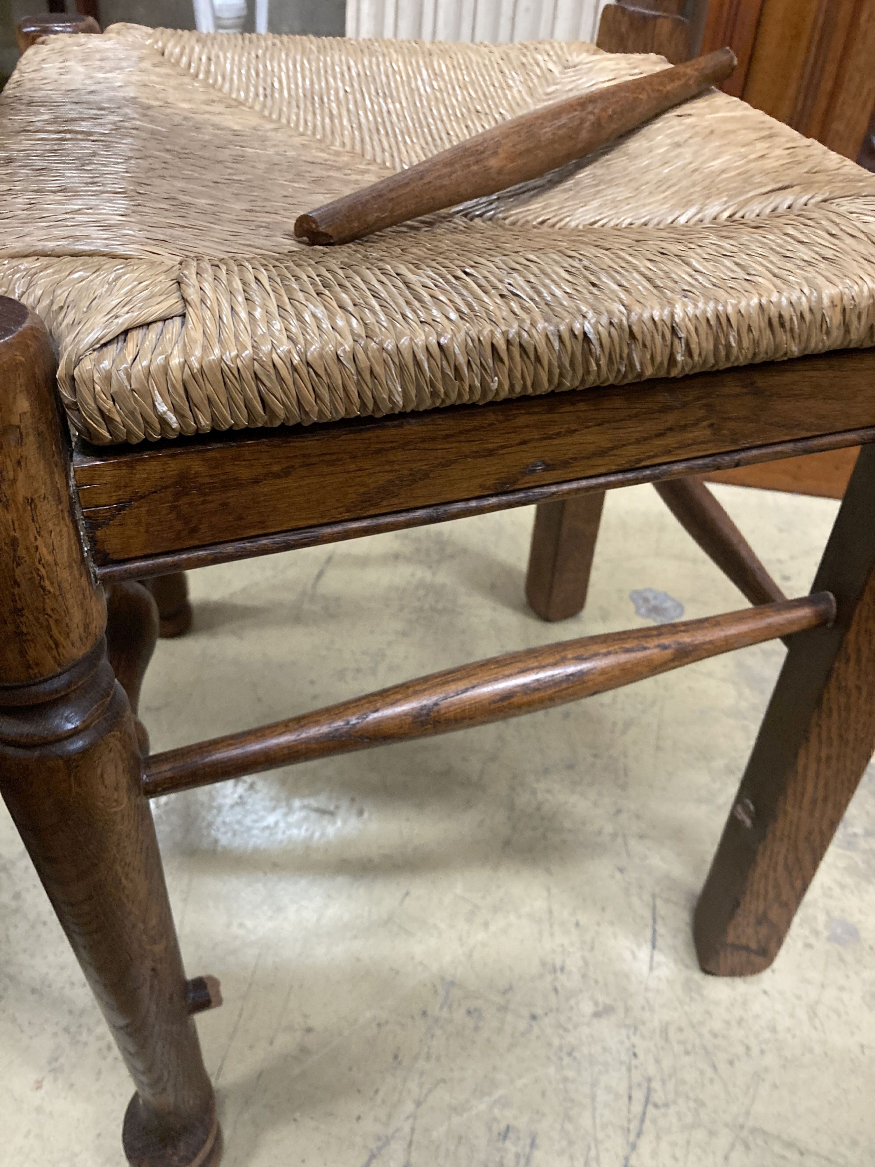 A set of eight 18th century style oak rush seat ladderback dining chairs, (two with arms)